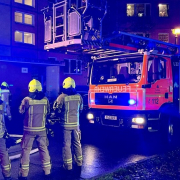 Feuerwehrleute im Einsatz mit Feuerwehrauto