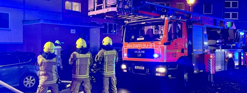 Feuerwehrleute im Einsatz mit Feuerwehrauto