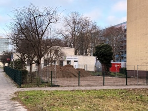 eingez&auml;unte glatte Grundst&uuml;cksfl&auml;che mit Sandhaufen