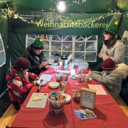 WG Solidarität Kinder sitzen an einem Tisch und verzieren Kekse.