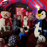 WG Solidarität Kinder erzählen dem Weihnachtsmann ihre Wünsche. Schneemann und Pinguin sind auch dabei.