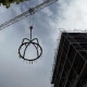 Richtkranz wird mittels eines Krahns auf den Neubau eines Mehrfamilienhauses gehoben