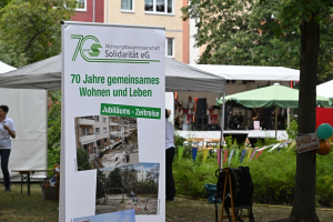 Blick auf eine Werbetafel zum siebzigsten Jubil&auml;um mit bildlicher Zeitreise
