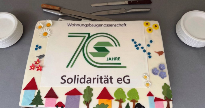 dekorative Torte mit einer gro&szlig;en gr&uuml;nen 70 sowie H&auml;usern, B&auml;umen und Blumen